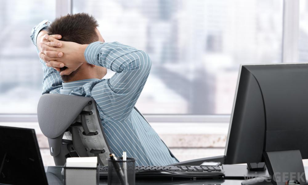 a man relaxing at his desk at work