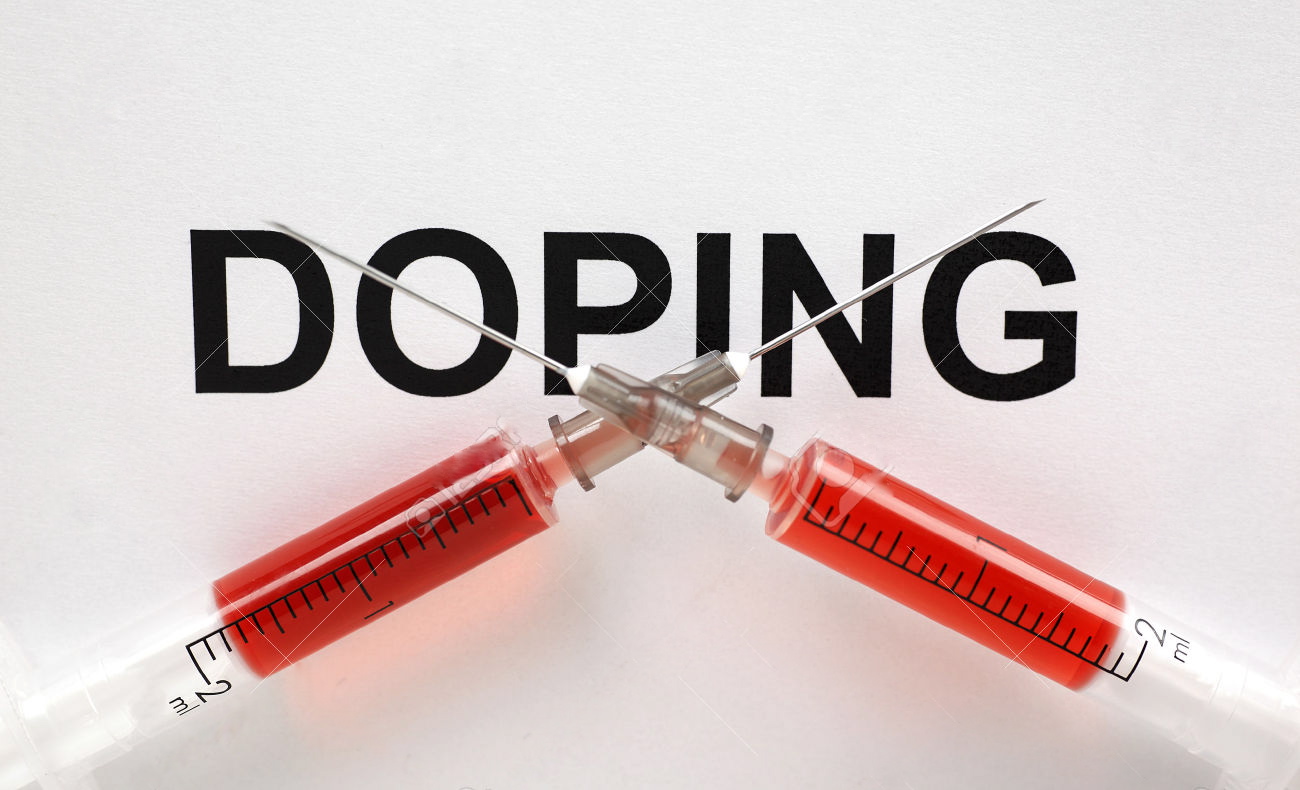 30098282 Two syringes filled with red liquid word doping written in capital letters in background Stock Photo